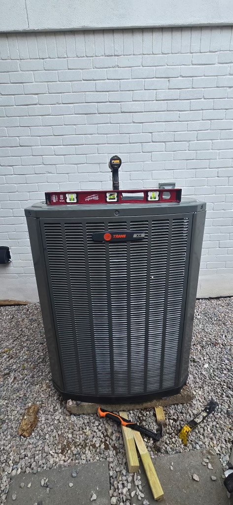 Front view of installed condenser with a level across the top